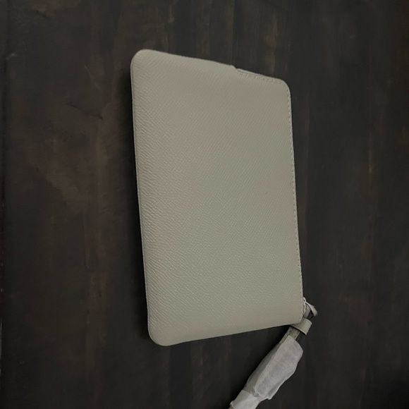 Light grey coach wristlet, with a silvery, gold coach written on it. - Picture 2 of 3